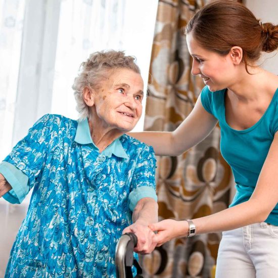 Home care nurse assisting elderly woman